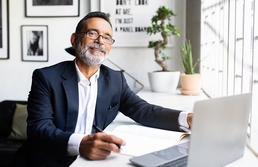CEO/executive on laptop thinks about his biggest leadership weaknesses