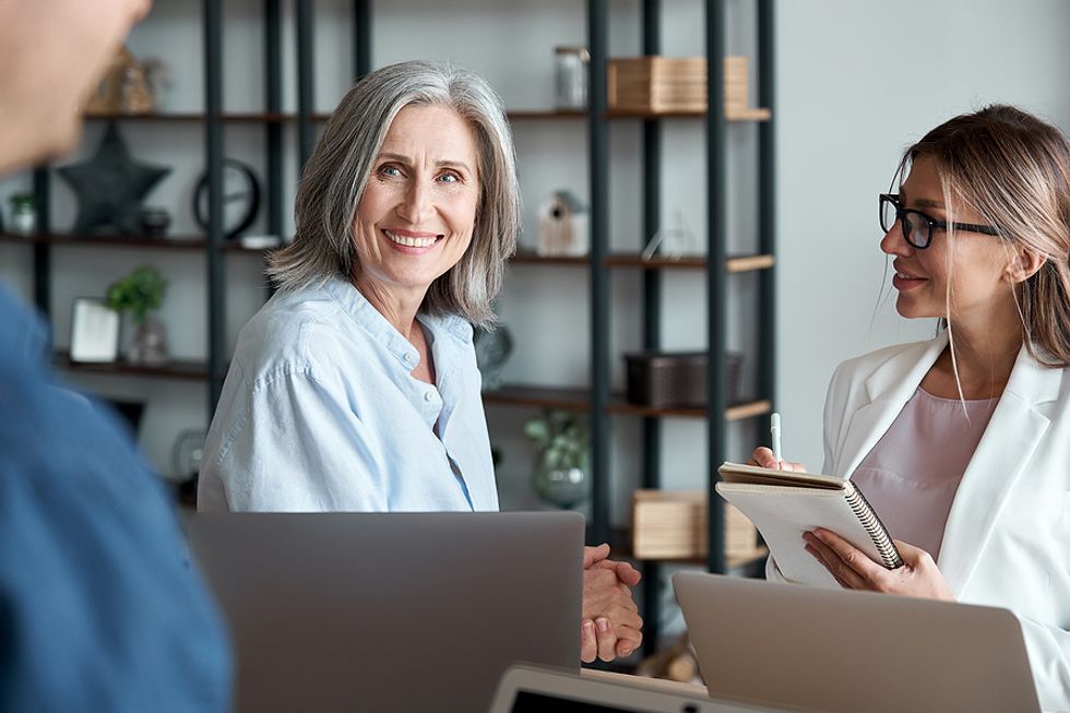 CEO/leader communicates with her team members during a work meeting