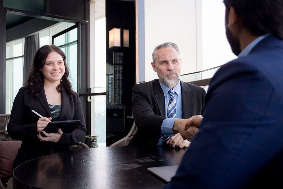 CEO shakes hands with another executive during a meeting