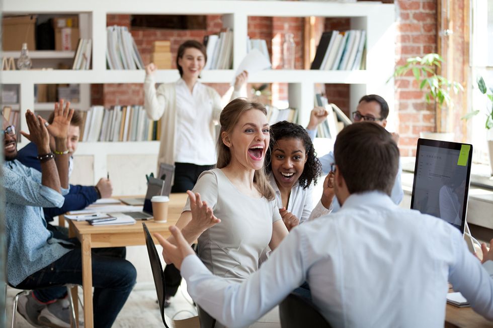 Co-workers celebrate promotion announcements at work.