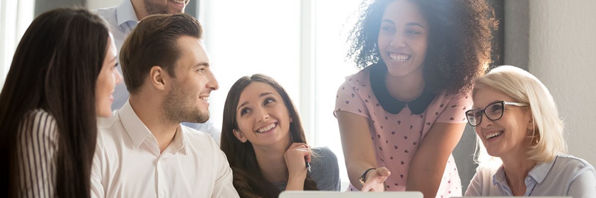 Co-workers laugh during a discussion about company culture.