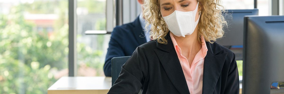 Co-workers wear masks in the office to help reduce the spread of COVID-19 while at work.