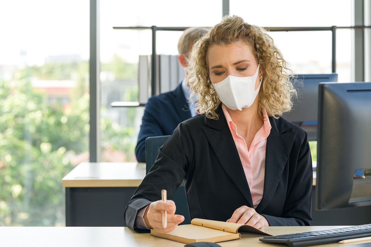 Co-workers wear masks in the office to help reduce the spread of COVID-19 while at work.