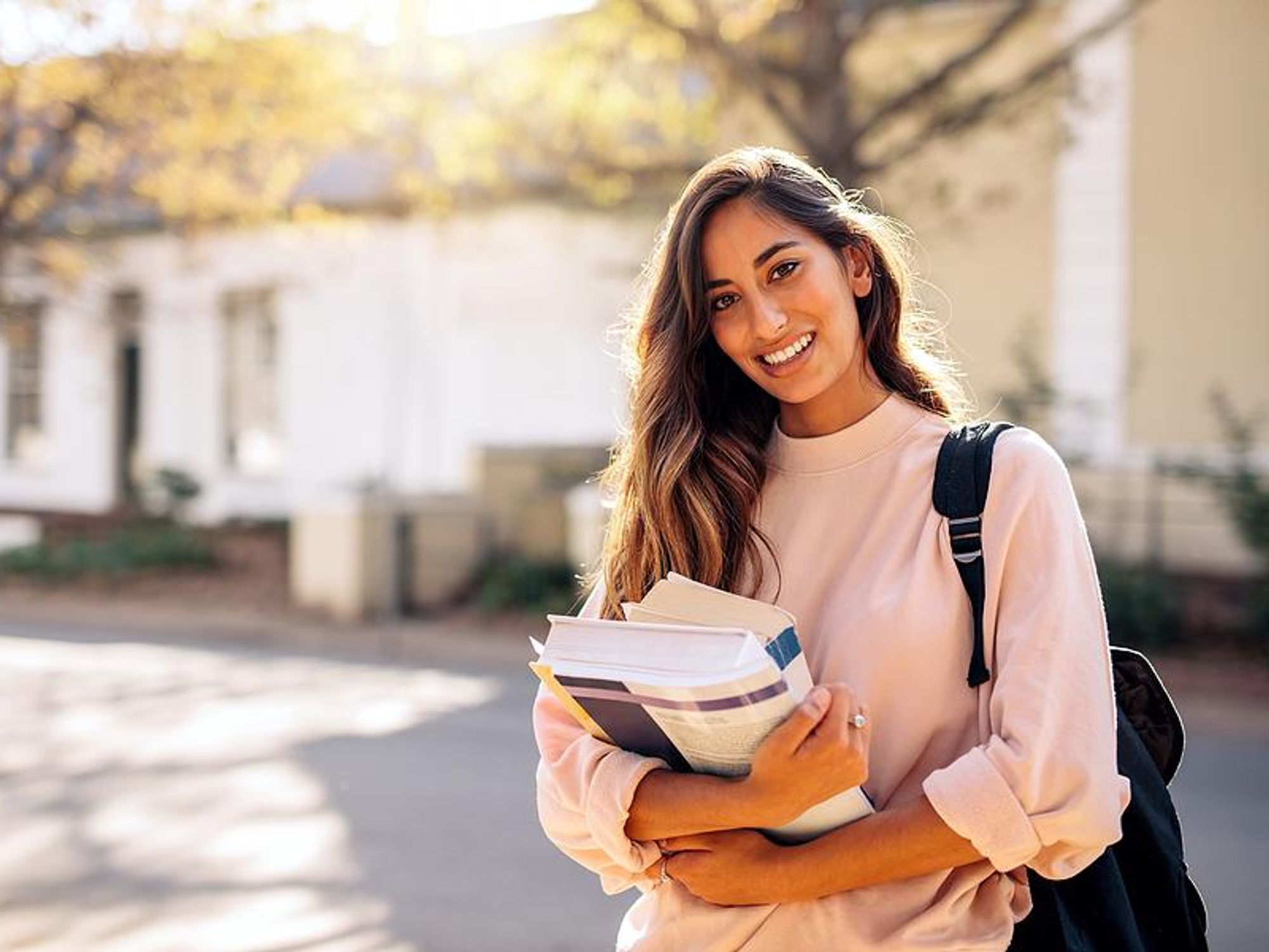 College student carries books to her classes