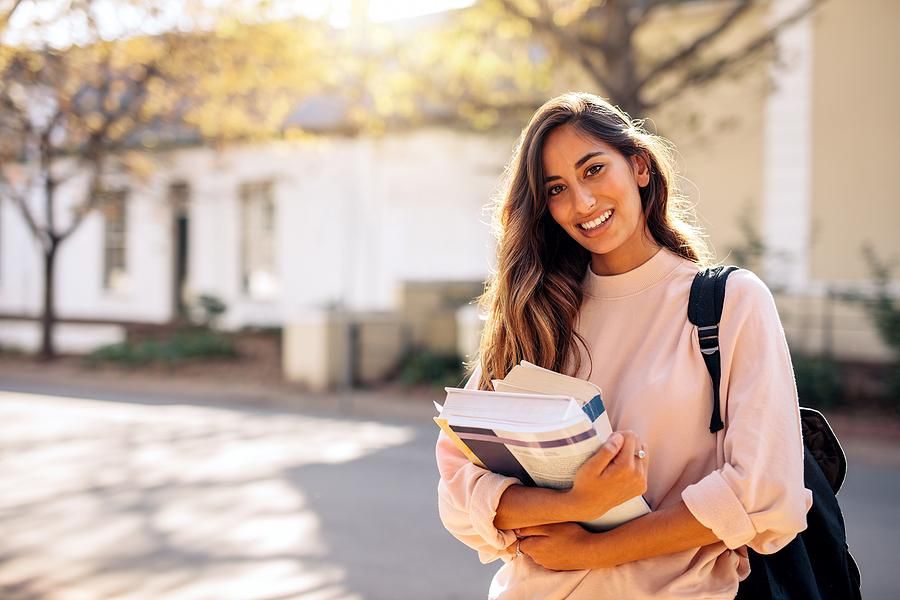 College student carries books to her classes