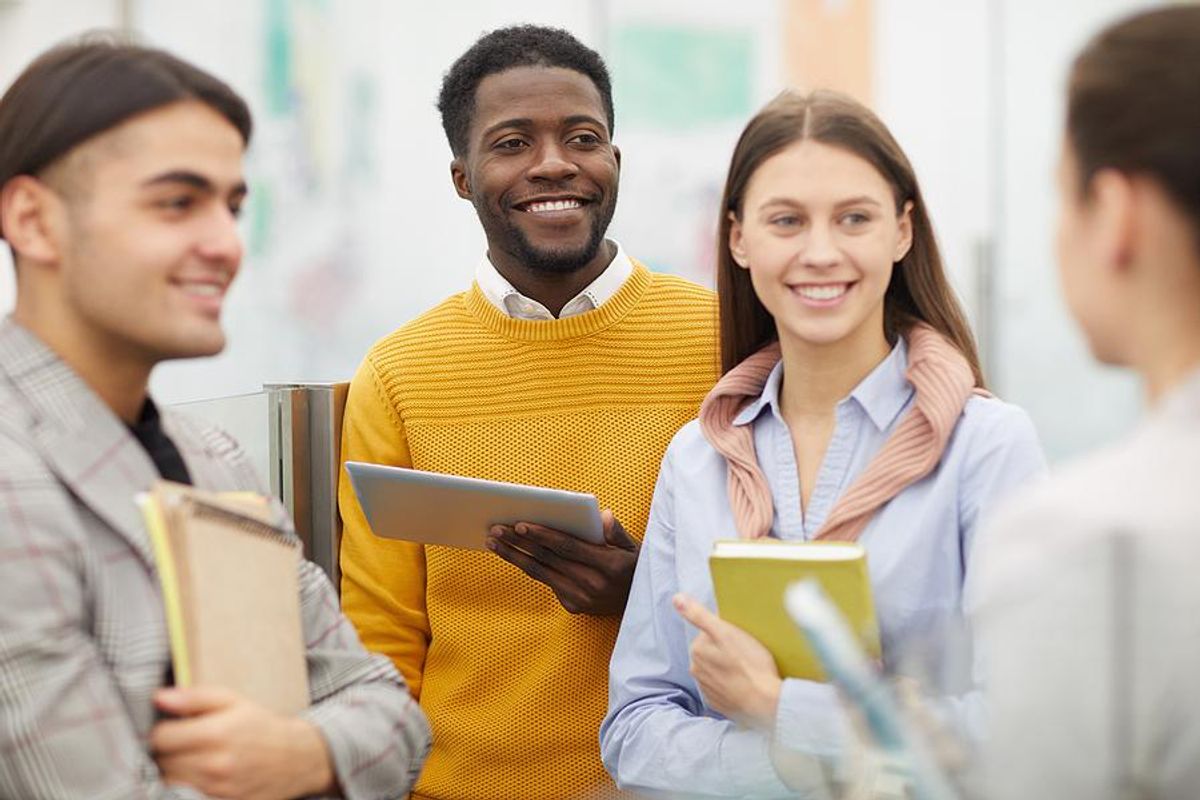 College students and grads listen to someone at a job fair
