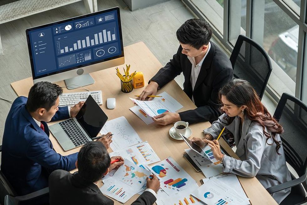 Communications and business professionals look at data during a work meeting