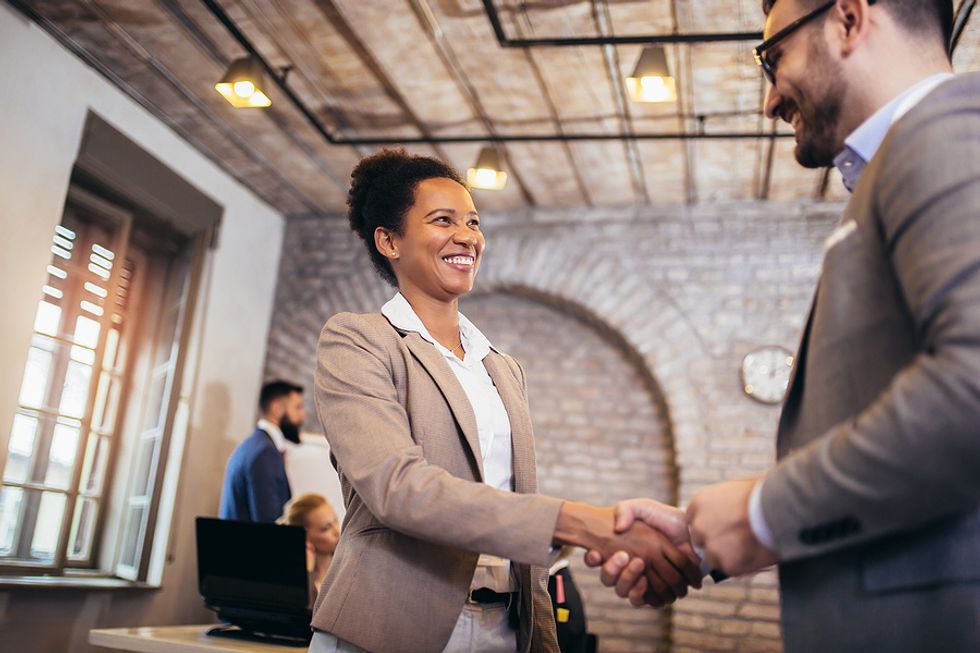 Confident woman greets the hiring manager with a handshake during a job interview