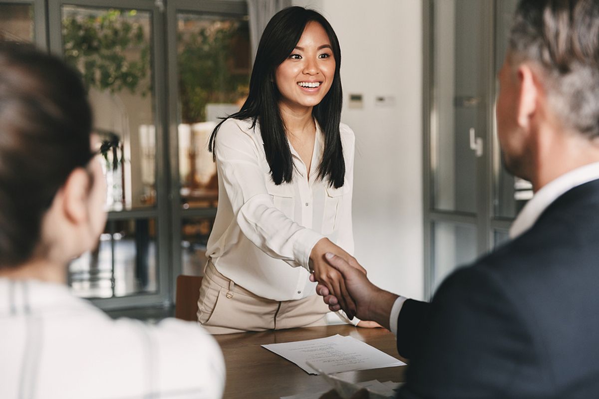 Confident woman shakes the hand of the hiring manager before a job interview