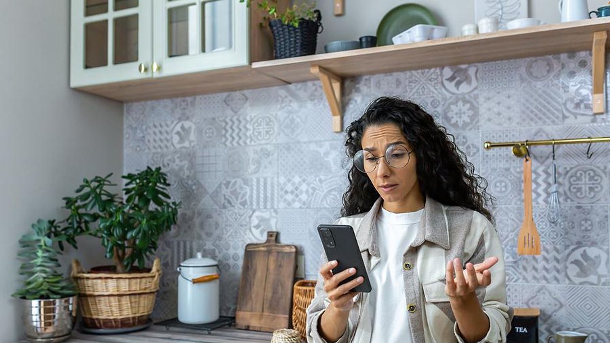 Confused woman looks for a job on her phone