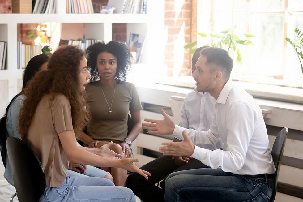 Coworkers argue about something during a work meeting