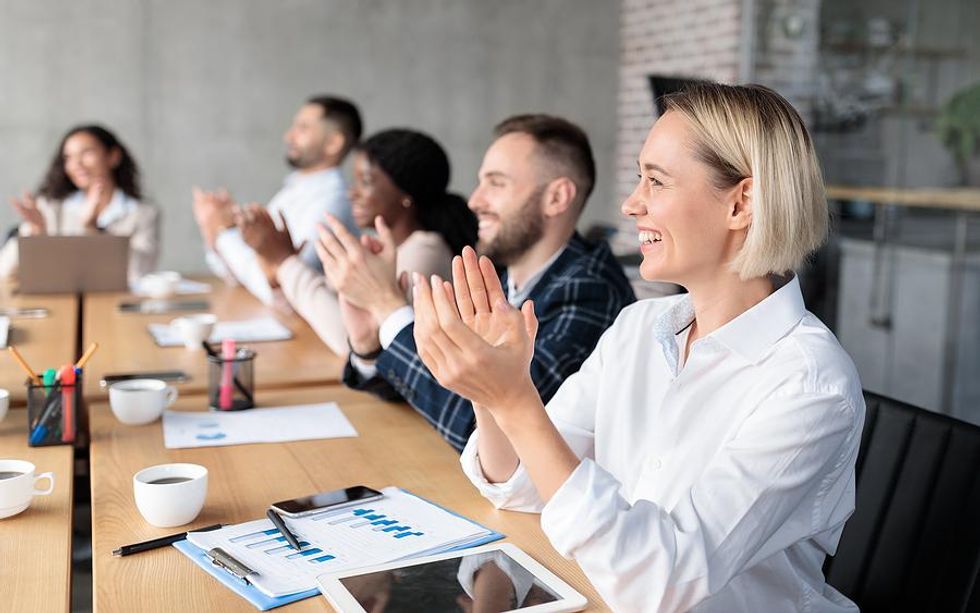 Coworkers clap after a presentation