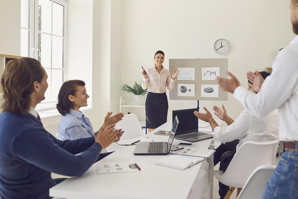 Coworkers in a meeting celebrate achieving their "March Madness" goals