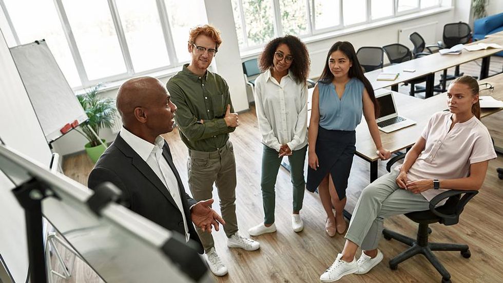 Coworkers listen to their boss