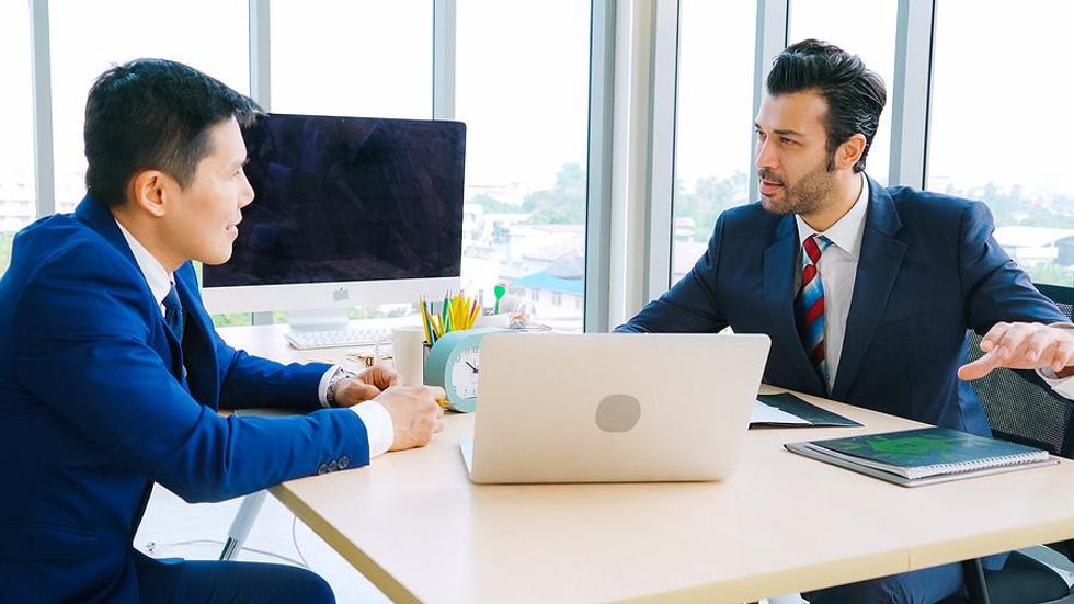 Coworkers resolve a workplace disagreement during a work meeting