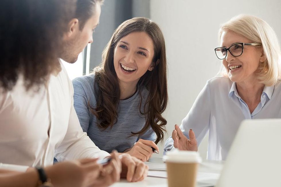 Coworkers share a laugh during a company meeting.