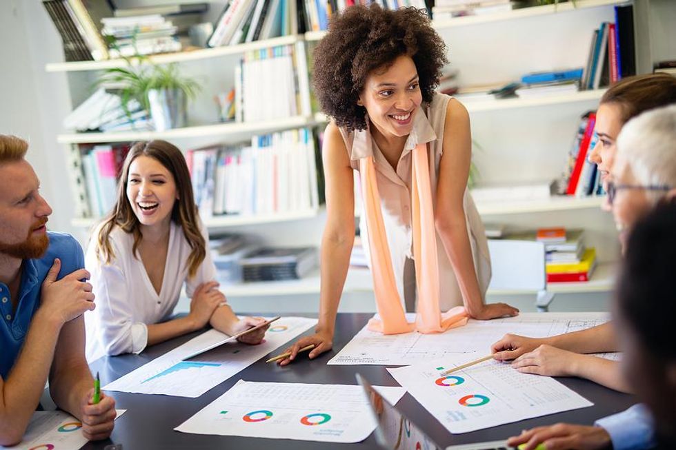 Coworkers talk in a meeting and have a great day at work