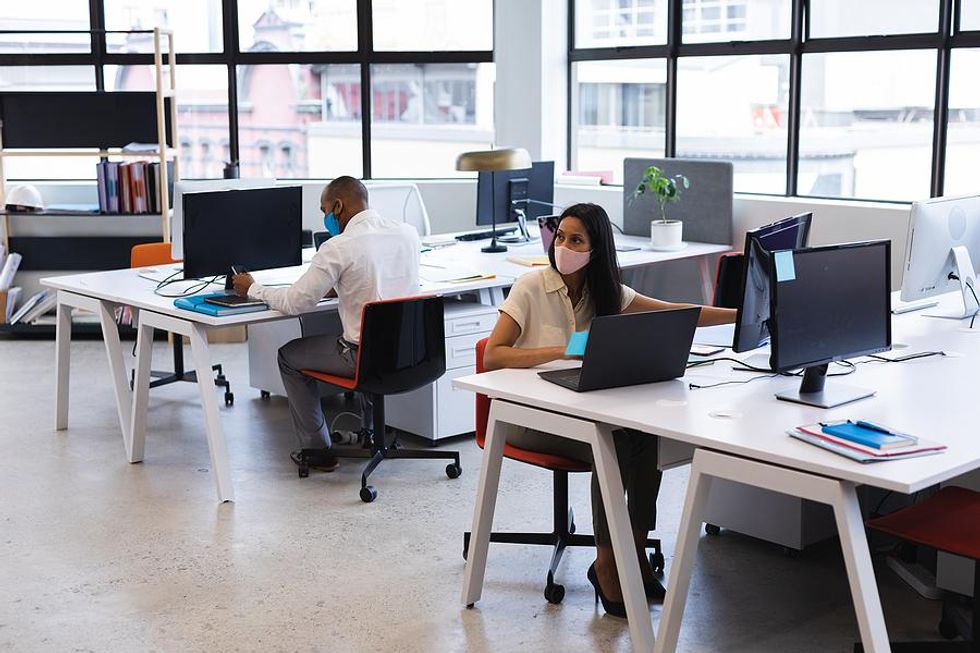 Coworkers work in a socially distanced office following COVID-19.