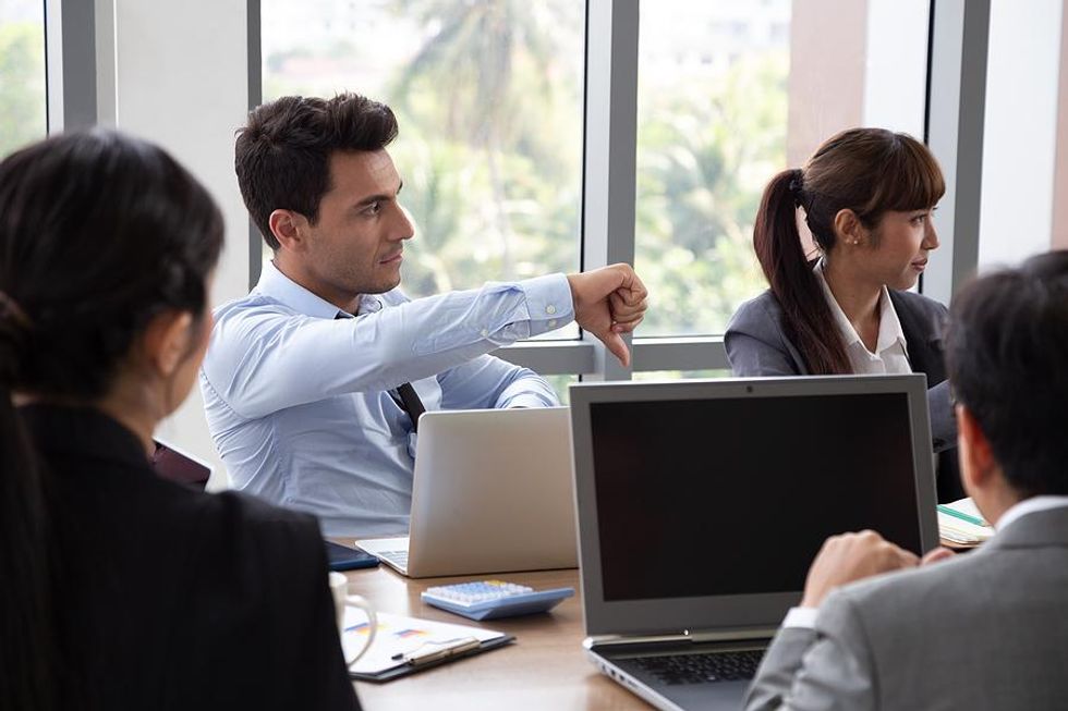 Difficult stakeholder gives the thumbs-down during a work meeting