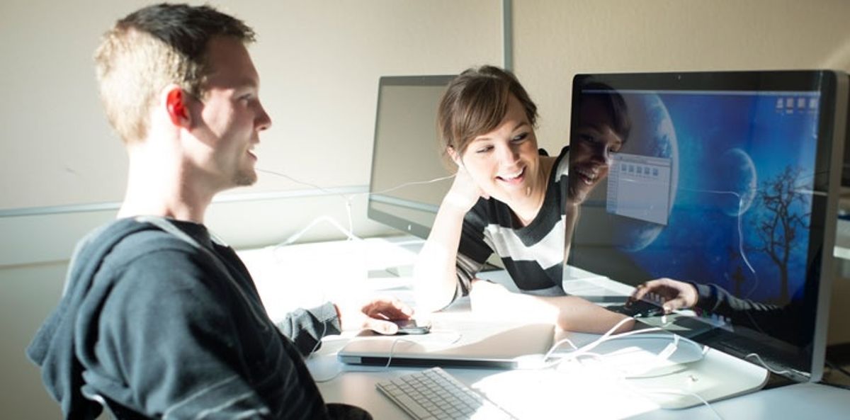 Digital marketing associates discuss a work project.