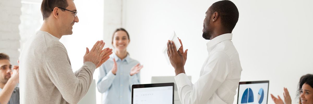 Employees applaud a co-worker who has done great work.