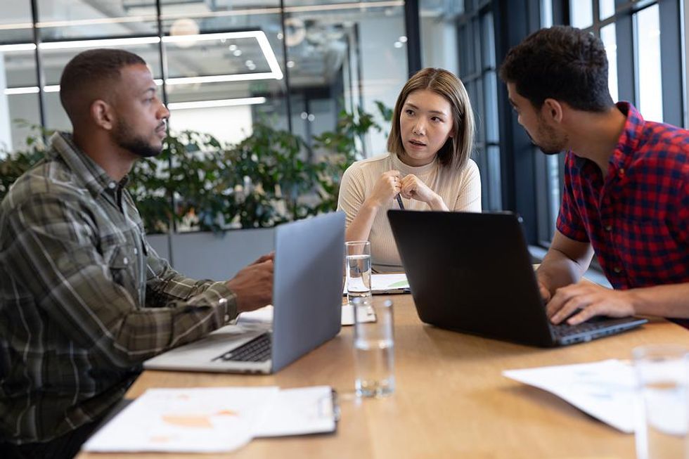 Employees talk about layoffs at work during a meeting