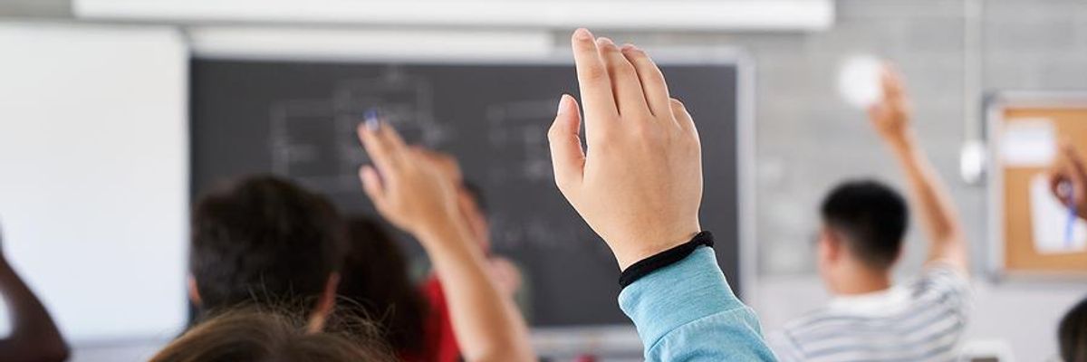 Engaged students raise their hands in class