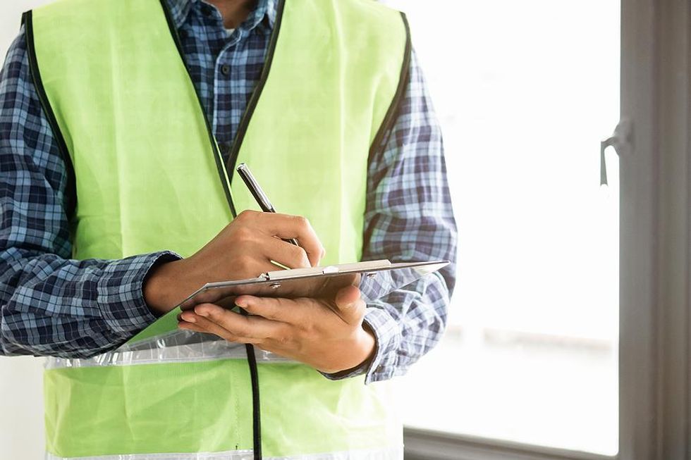 Engineer writes something down on his clipboard