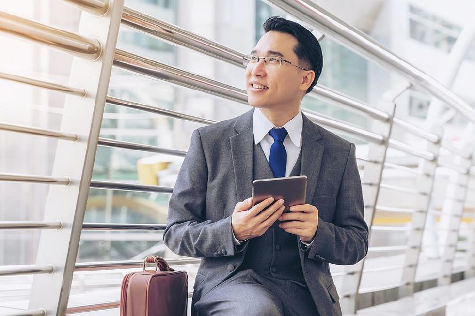 Executive/leader holds a tablet while traveling for work