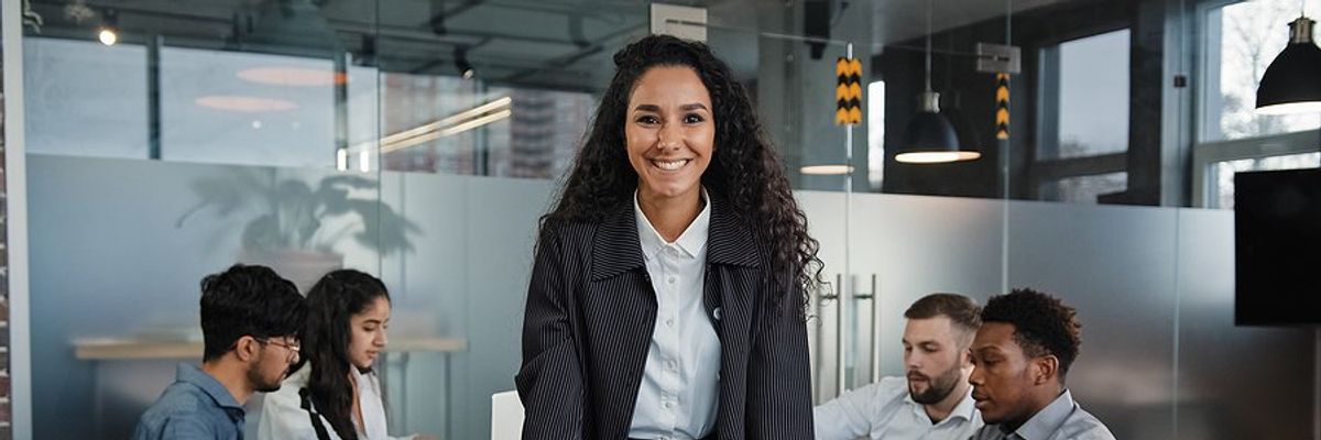 Executive/leader smiles and leads her team during a meeting