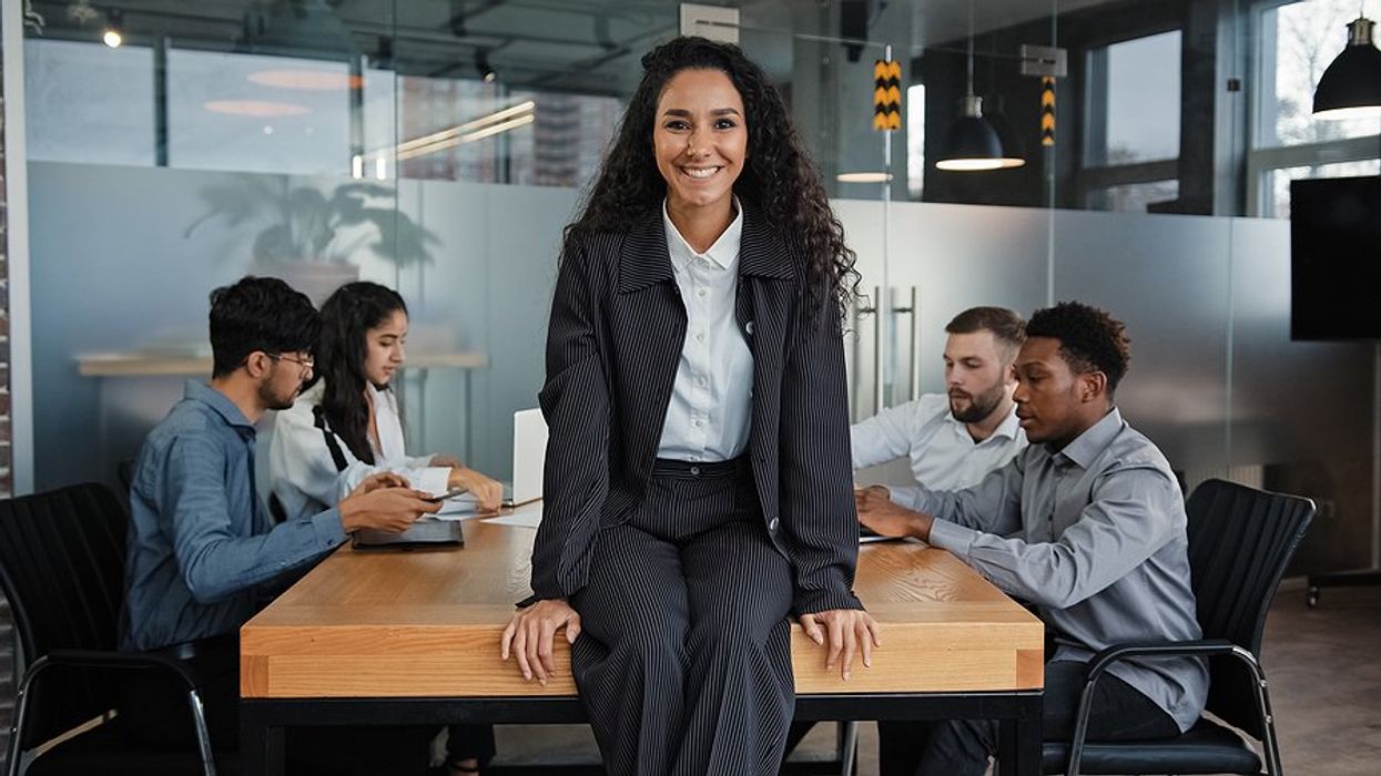 Executive/leader smiles and leads her team during a meeting