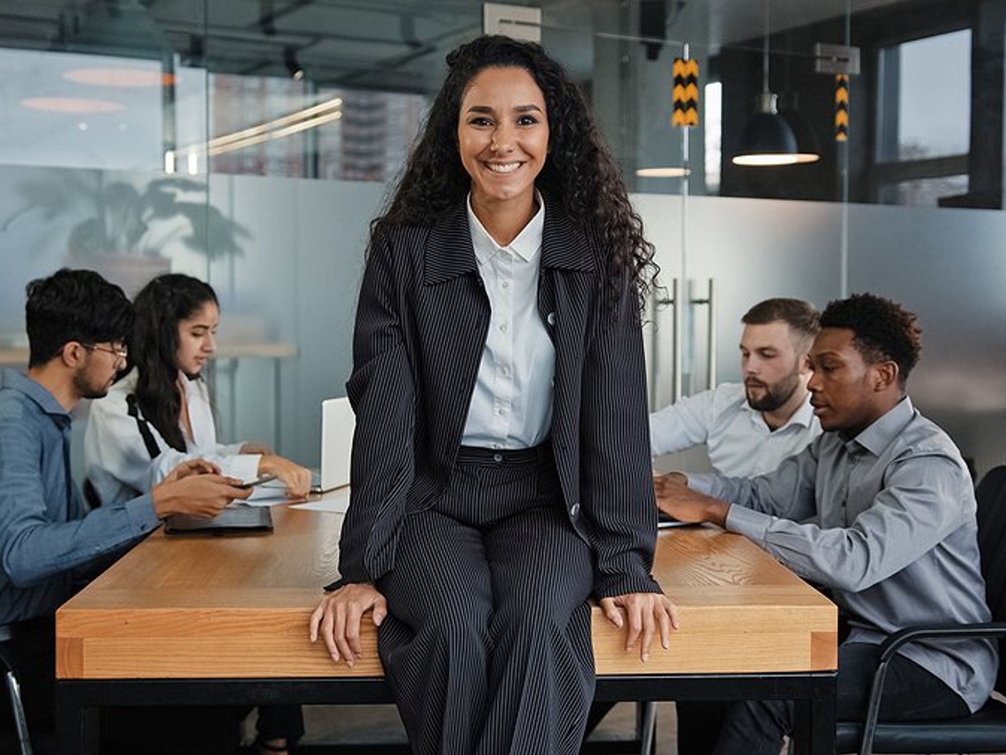 Executive/leader smiles and leads her team during a meeting