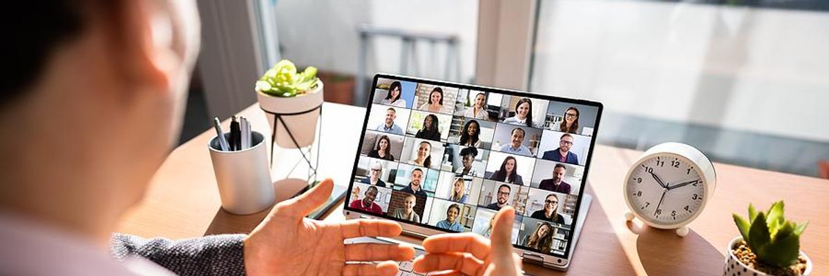 Executive/leader talks to his hybrid employees on his laptop