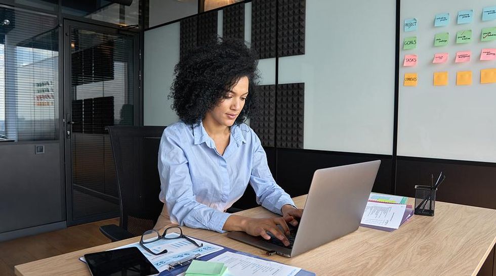 Executive/leader works on her laptop at work