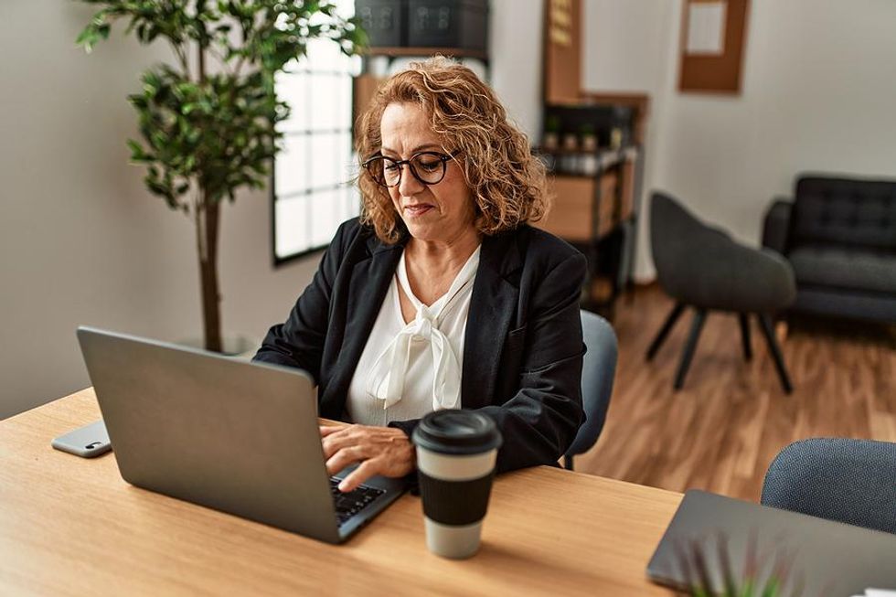 Executive on laptop updates her LinkedIn profile