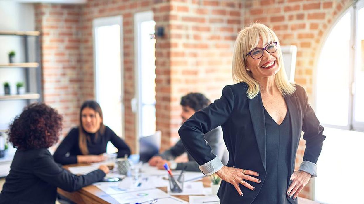 Executive stands and smiles during a work meeting