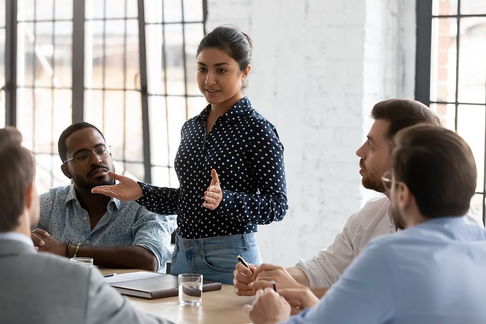 Female executive mentors a group of colleagues