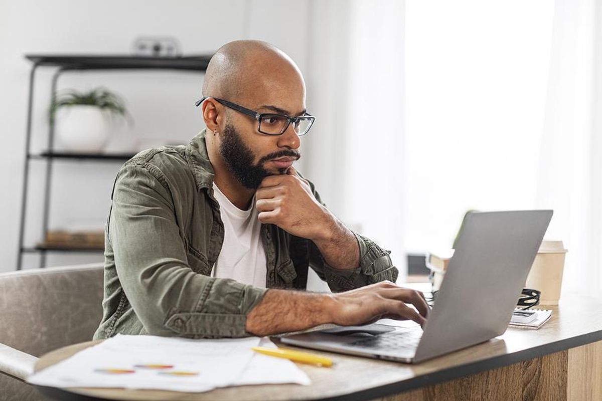 Focused man on a laptop looks for a job