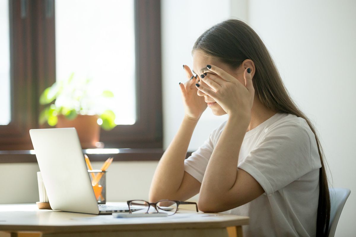 Frustrated/stressed woman on laptop figures out the reasons why she's unemployed