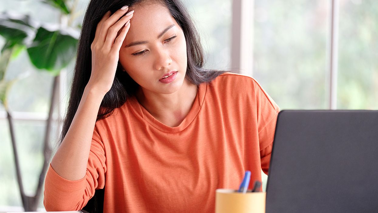 Frustrated woman on laptop struggling to stay motivated while looking for a job