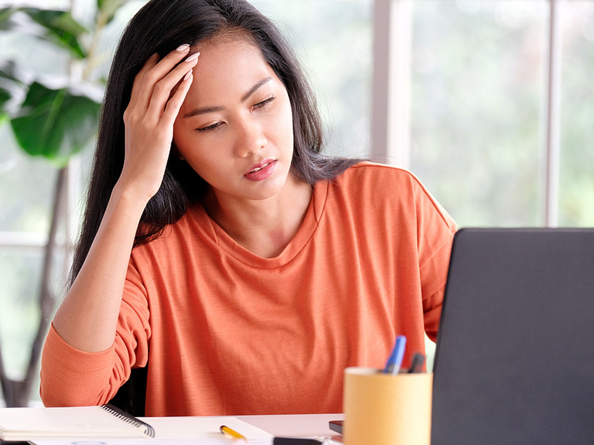 Frustrated woman on laptop struggling to stay motivated while looking for a job