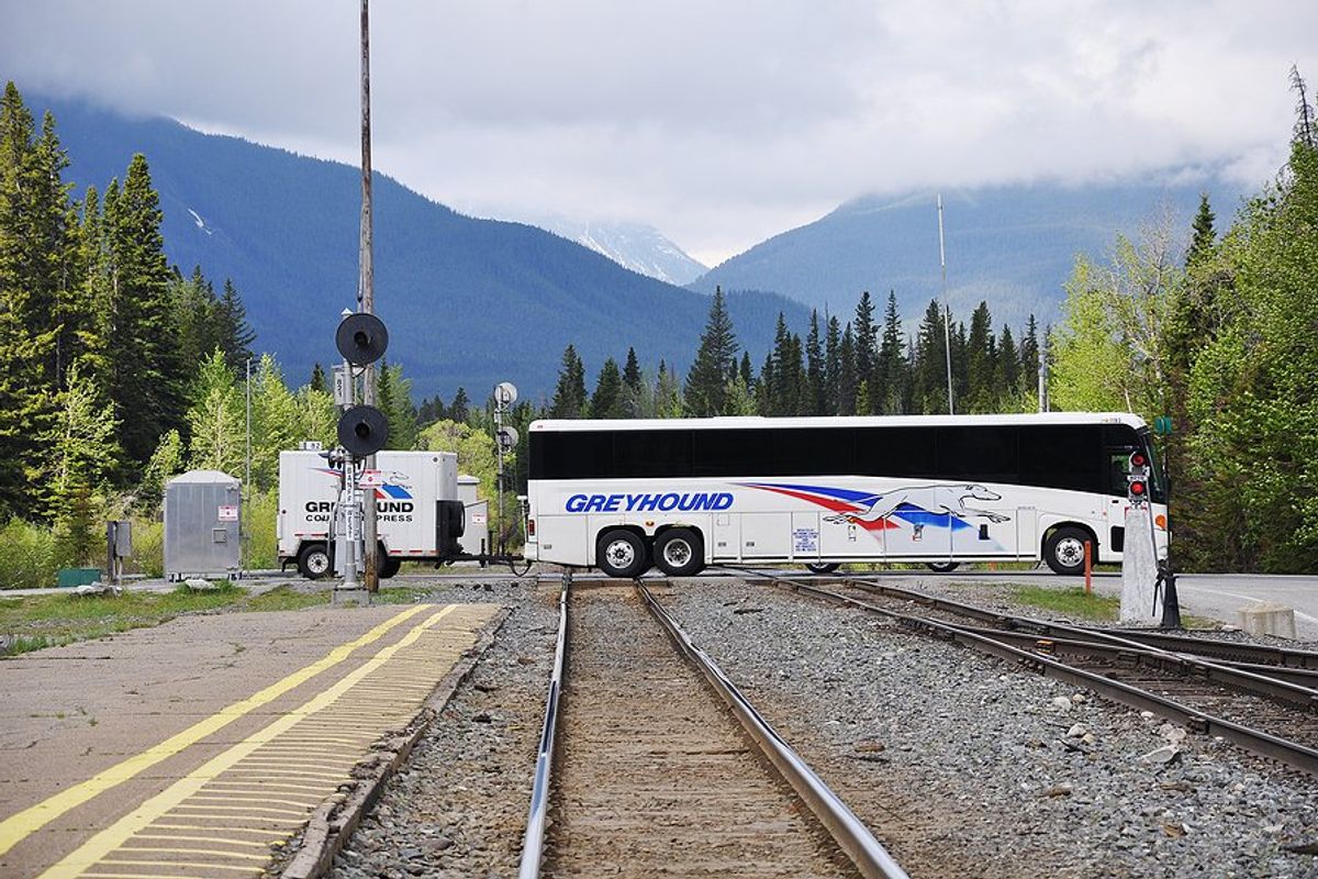 Greyhound bus crosses train tracks in Banff, Canada