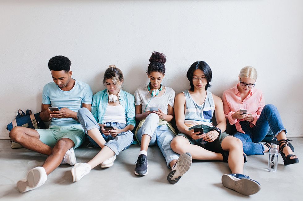 Group of college students browsing social media on mobile phone