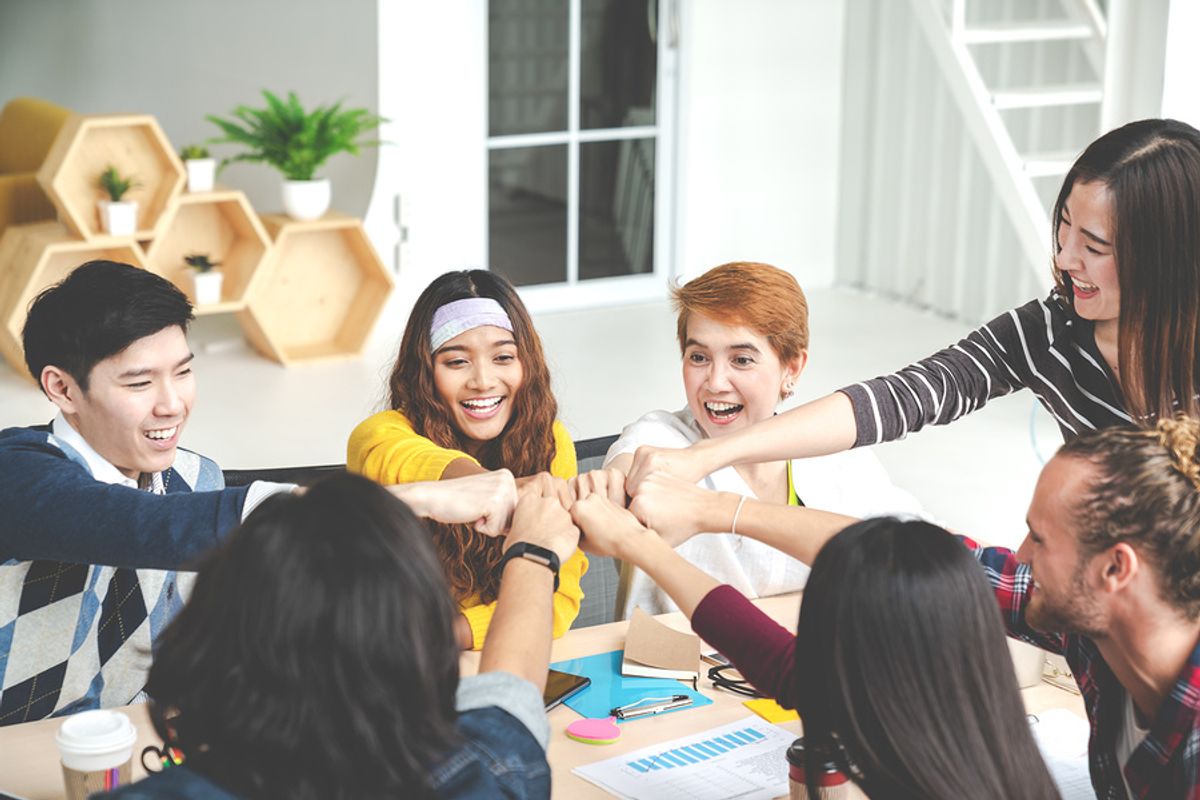 Group of coworkers celebrate during a work meeting at a company with strong core values