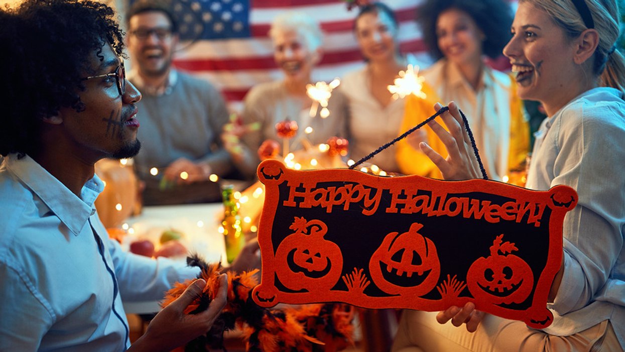 Group of coworkers dressed up in costumes and celebrating Halloween at work