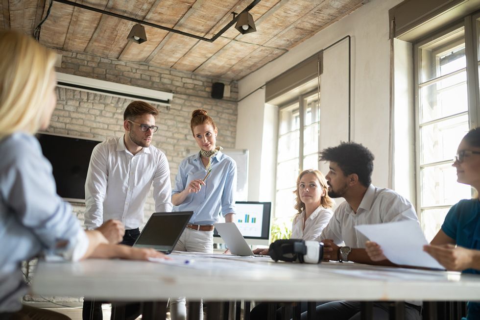 Group of employees in an ethical workplace talk during a meeting