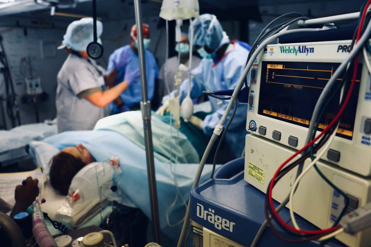 Group of people/doctors doing a surgery on a person inside the operating room