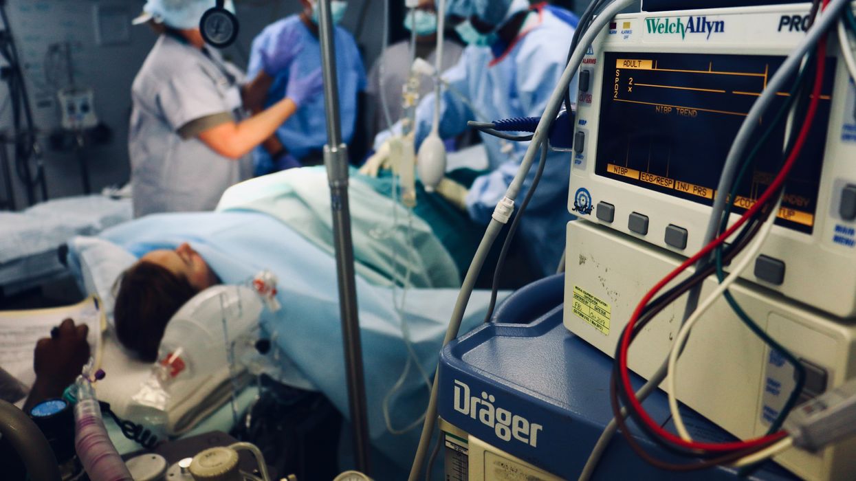 Group of people/doctors doing a surgery on a person inside the operating room