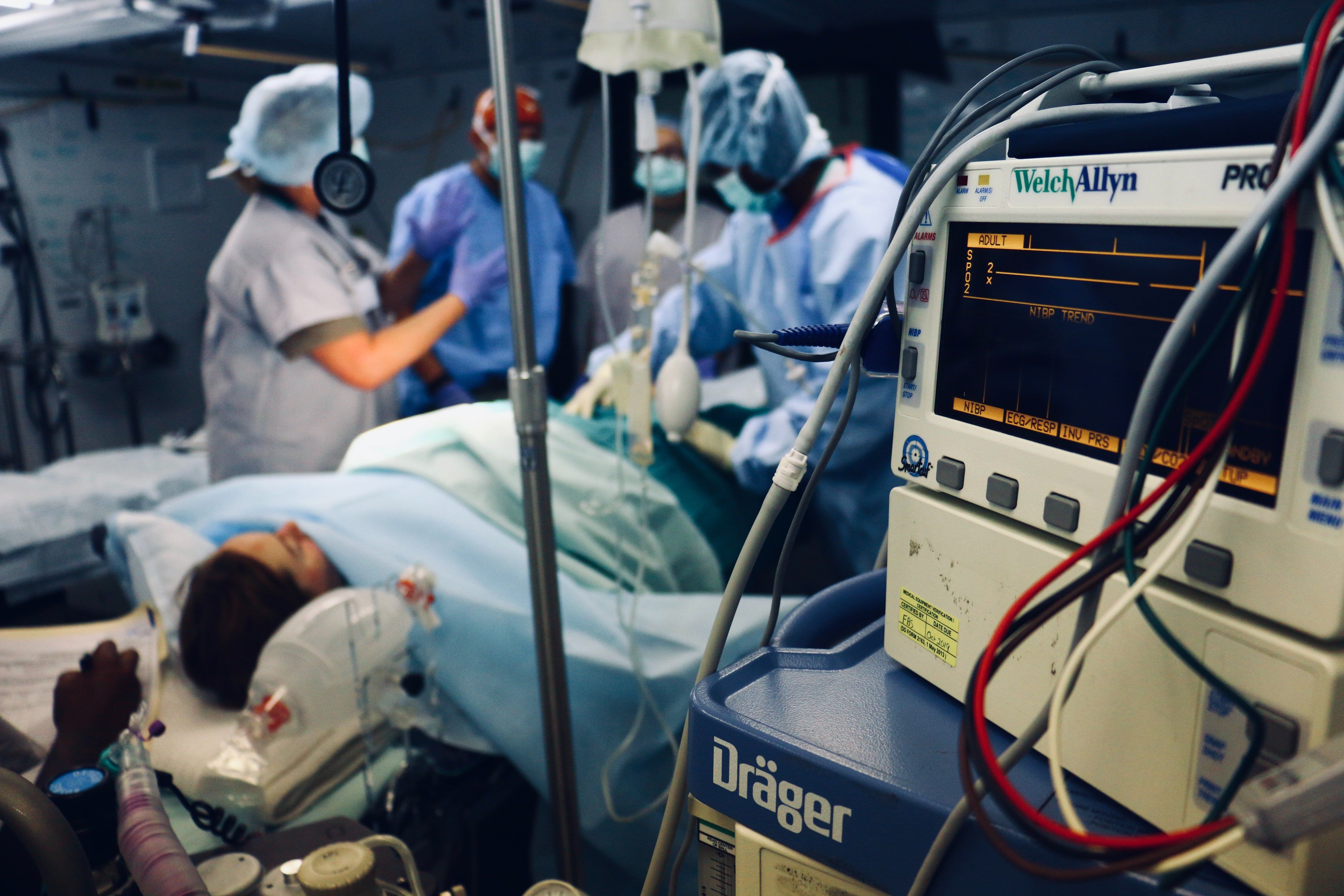 Group of people/doctors doing a surgery on a person inside the operating room