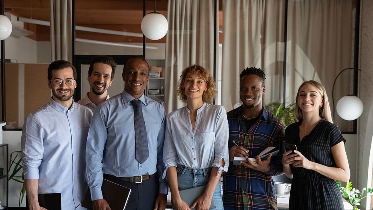 Group of professionals stand with an executive/leader